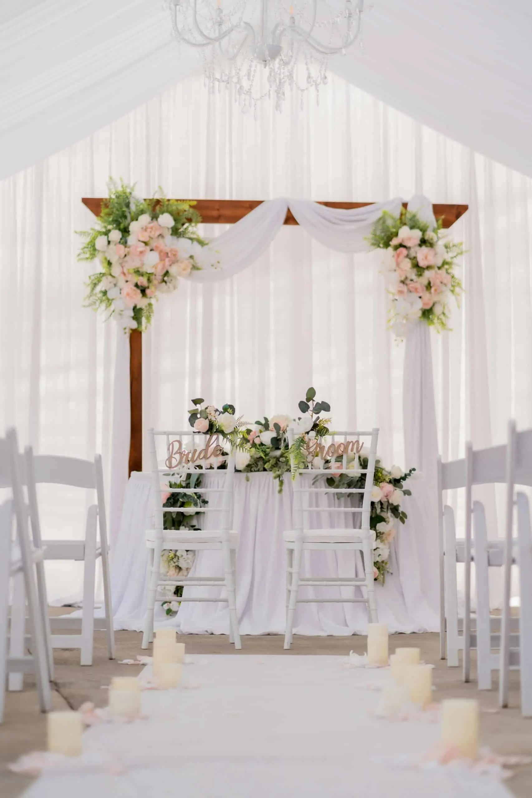 ozel-gun-nikah-duzeni-cicekli-susleme Beyaz tül ve çiçeklerle süslenmiş nikah alanı, özel günler için şık masa ve sandalye düzeni.